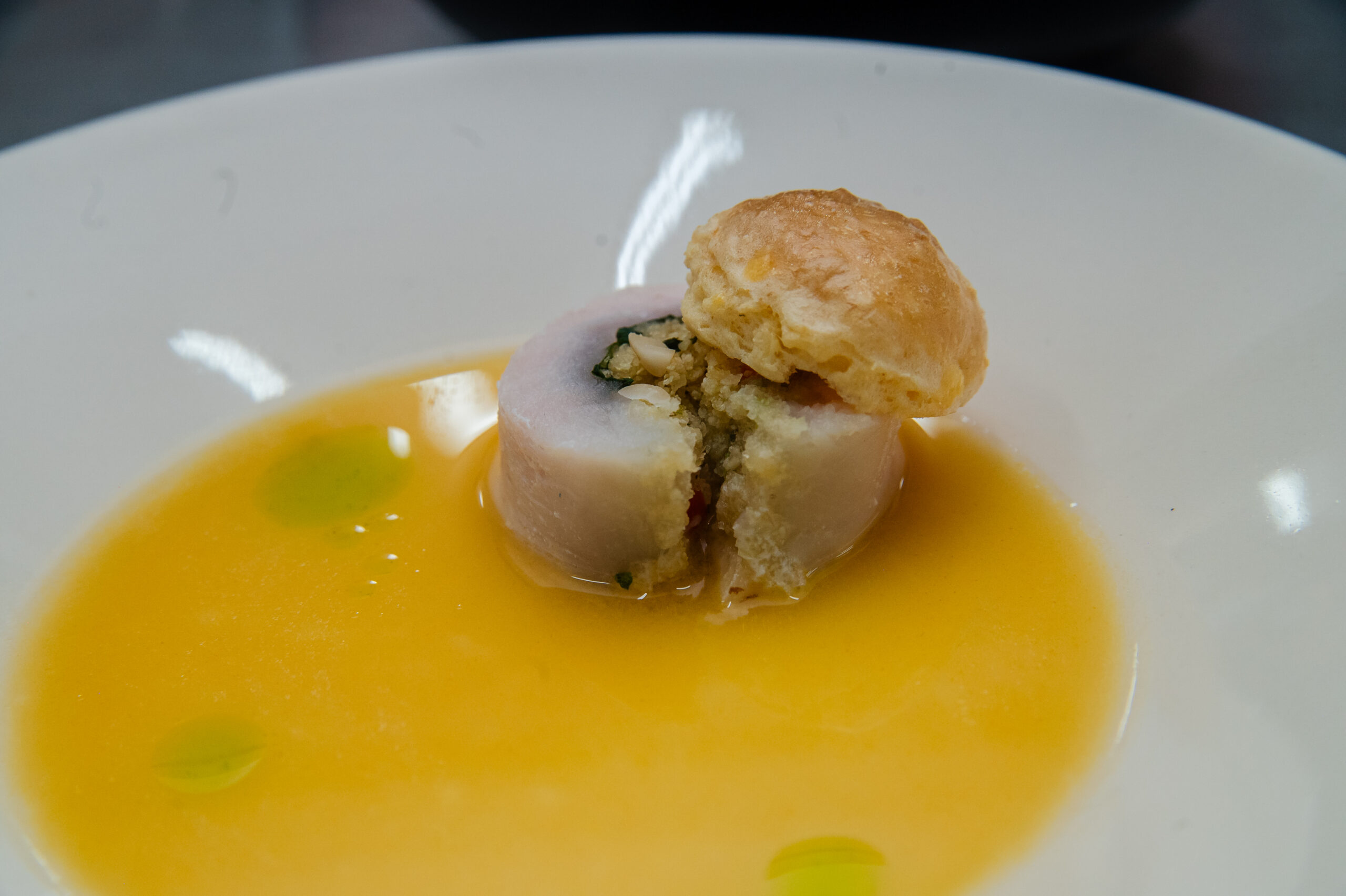 Ballotine de pirarucu com cuscuz, jambu, óleo verde de chicória e consommé de tucupi